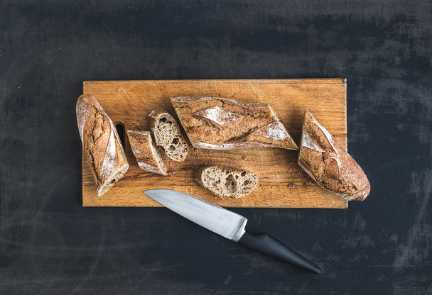 French baguette cut into pieces on a rustic wooden board - Photo, Image