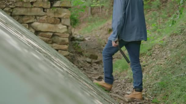 Plan long du pensionné masculin à l'aide d'un marteau tout en fixant le mur de la maison dans la forêt - Séquence, vidéo
