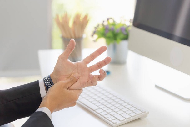 Man lijdt pijn in handen en vingers, Ongezonde kantoorman handblessure - Foto, afbeelding
