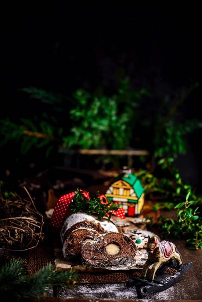 Christstollen Schwarzwald auf weihnachtlichem rustikalem Hintergrund. Stil rustikal. Selektiver Fokus - Foto, Bild