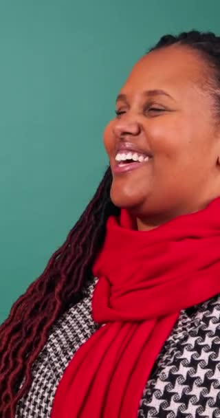 Egy karácsonyi színekbe öltözött, nevető fiatal nő portréja, stúdió videó. Kiváló minőségű 4k felvételek - Felvétel, videó