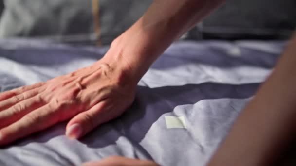 domácí rutina, žena ruka vyhlazuje postel od vrásek, detailní záběr - Záběry, video