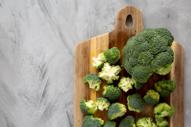 Organic Raw Broccoli Florets on a wooden board, top view. Flat lay, overhead, from above. Copy space. - Photo, Image