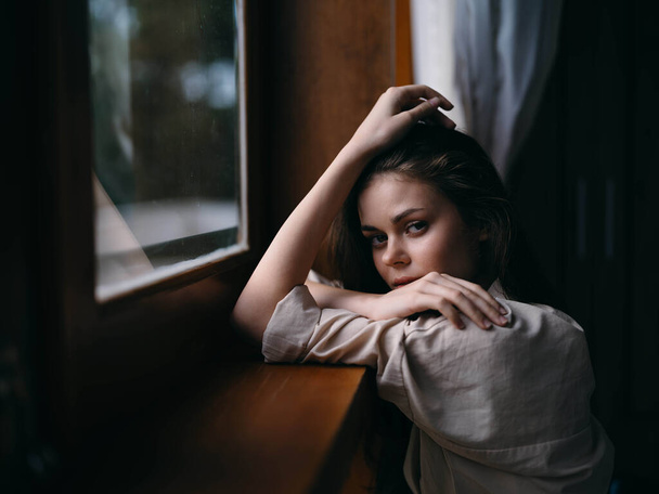 Retrato de mujer joven en casa por ventana con marco de madera, estado de ánimo de otoño, estilo de vida acogedor, tiempo somnoliento. Foto de alta calidad - Foto, Imagen