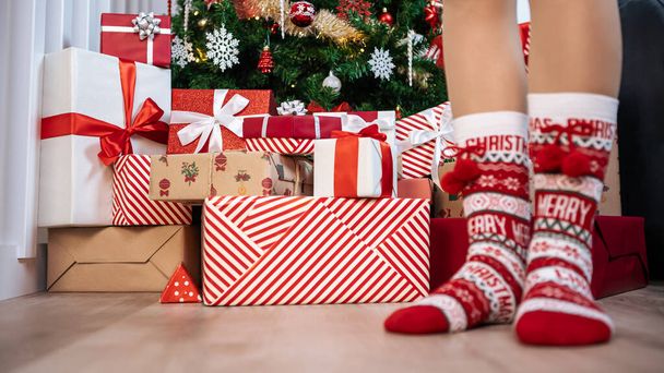Gyönyörű csomagolt ajándékdobozok alatt egy modern karácsonyi dekoráció fa otthoni háttér. Fir díszített ünnep Xmas díszek. Új év dekoráció design elem - Fotó, kép