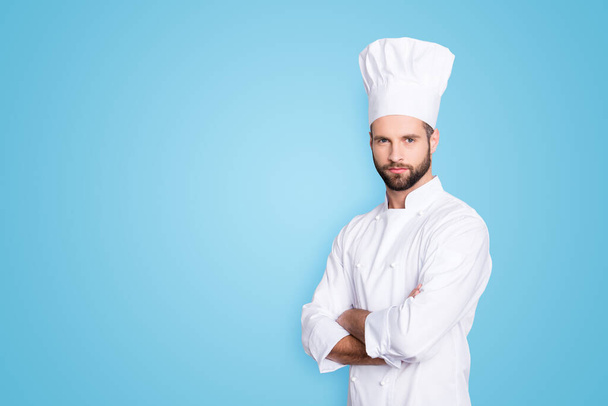 Portrait with copy space, empty place for advertisement, product of harsh virile chef cook with stubble in beret, white outfit having his arms crossed, isolated on grey background. - Fotografie, Obrázek