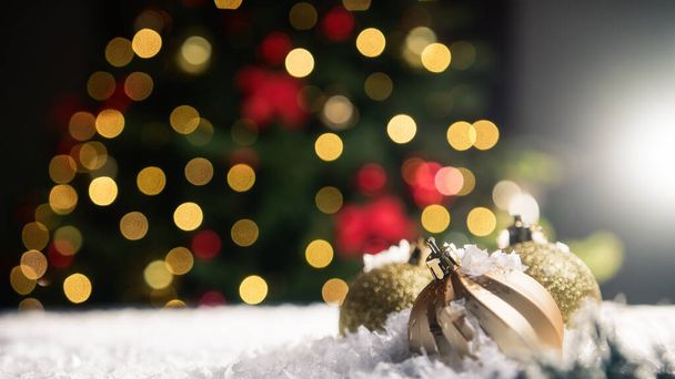 Χριστουγεννιάτικες μπάλες στο χιόνι με το δέντρο στο φόντο . - Φωτογραφία, εικόνα