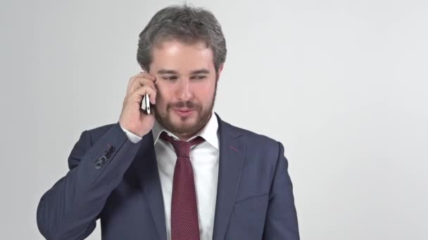 Businessman in suit with tie smiling and talking on the phone full video - Materiał filmowy, wideo