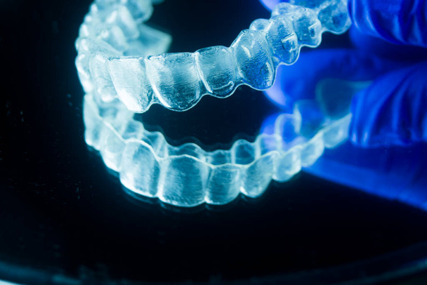 Σύγχρονα αόρατα στηρίγματα aligner ισιωτικά που χρησιμοποιούνται για τη διόρθωση της ευθυγράμμισης στα δόντια από οδοντίατρους. - Φωτογραφία, εικόνα