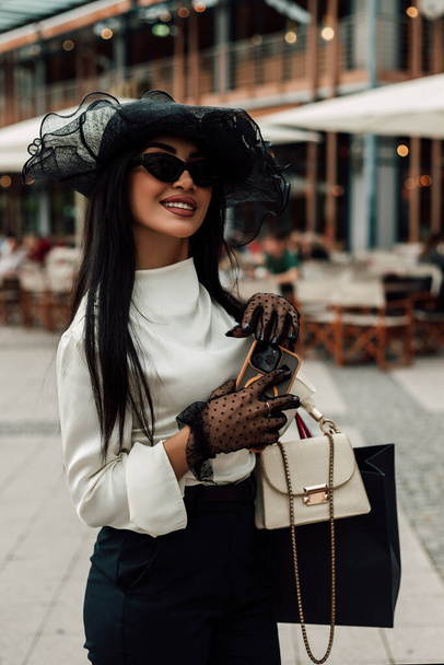 Modna młoda kobieta w kapeluszu z torbami na zakupy. Zakupy dla kobiet. Wysokiej jakości zdjęcie - Zdjęcie, obraz