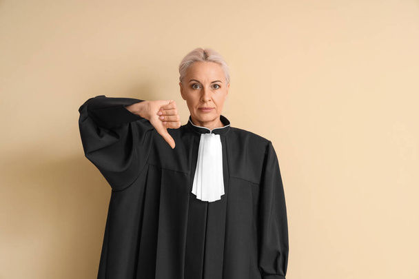 Mature judge showing dislike on beige background - Photo, Image