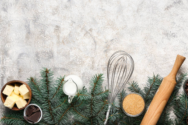 Bella composizione con diversi ingredienti per la preparazione di torta di Natale e rami di abete su sfondo grigio - Foto, immagini
