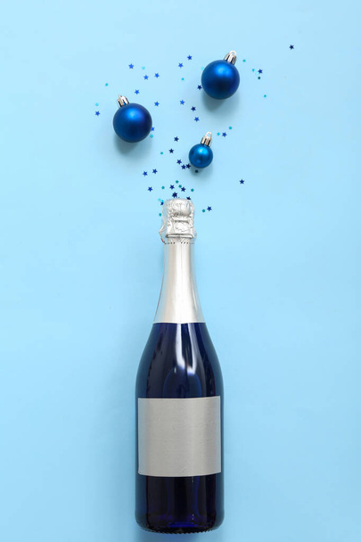 Butelka szampana z wystrojem świątecznym na niebieskim tle - Zdjęcie, obraz