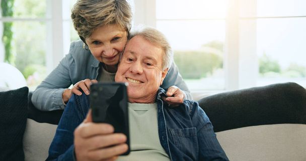 Telefon, idős vagy boldog pár a közösségi média kanapén a kommunikáció, mém vagy internet kapcsolat. Otthon, érett férfi vagy nő a mobil app keresni, pihenni vagy görgetni online kanapén a nappaliban. - Fotó, kép