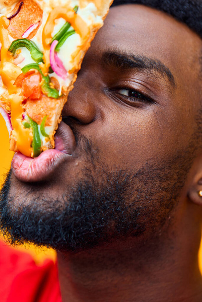 Еда человек ломтик красный доставка едок парень счастливый взрослый веселый мужчина едят пиццу быстро задний план стоял бородатый мужская еда черная диета улыбка студии - Фото, изображение