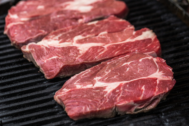 Fresh beef steaks on grill or BBQ - Фото, изображение