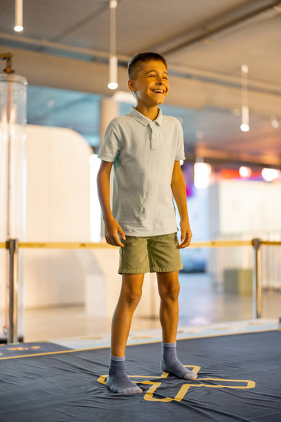 Petit garçon saute sur une aire de jeux intercalant avec des modèles d'apprentissage, visitant un musée des sciences. Concept de divertissement et d'apprentissage pour enfants - Photo, image