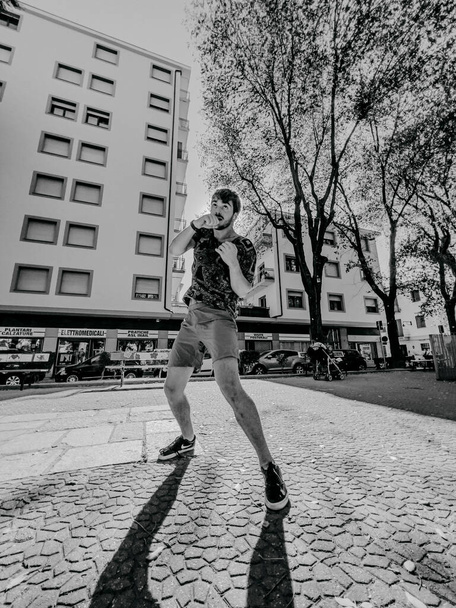 jonge bokser straatvechter traint op het plein tussen de gebouwen. Hoge kwaliteit foto - Foto, afbeelding
