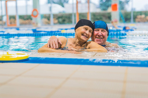 пожилая пара отдыхает в бассейне и обнимает друг друга, пожилые концепции любви. Высокое качество фото - Фото, изображение