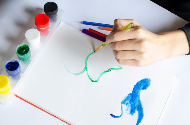 Levá ruka kreslí štětec s zelenou barvou na papíře v albu s se - Fotografie, Obrázek