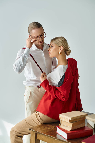 pohledný vousatý muž s brýlemi při pohledu na svou mladou sexy sekretářku v kanceláři, pracovní poměr - Fotografie, Obrázek