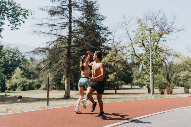 Aktives Paar beim gemeinsamen Turnen in einem sonnigen Park, Fitness, Motivation und natürlicher Umgebung - Foto, Bild