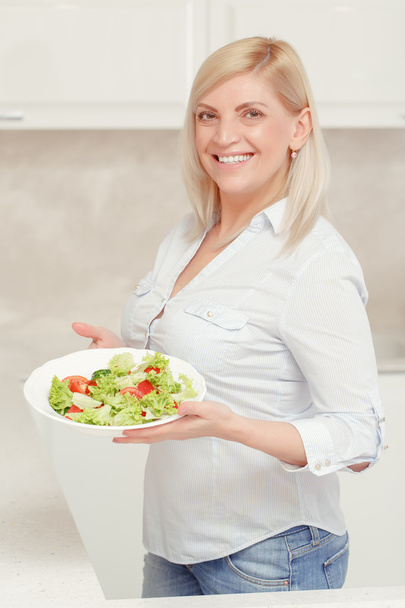 Женщина готовит салат на кухне
 - Фото, изображение