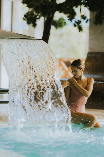 Bella giovane donna rilassante presso la piscina coperta - Foto, immagini