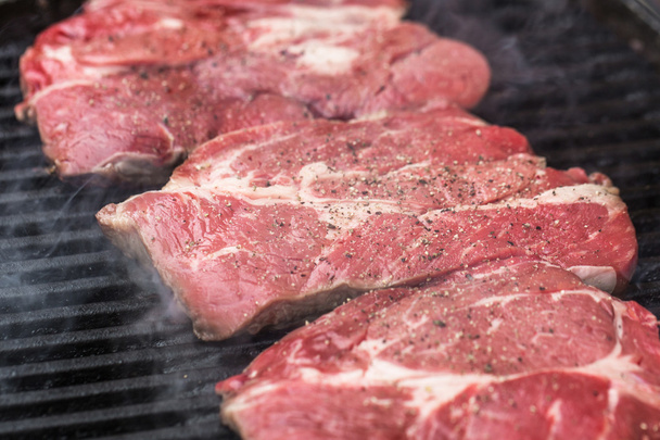 Fresh beef steaks on grill or BBQ - Фото, изображение