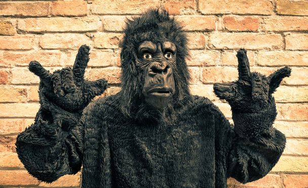 ロックン ロール手ジェスチャー - モダンな猿の擬人化の進化のヒップスター コンセプトで面白い偽ゴリラ - 写真・画像