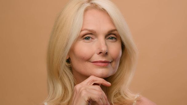 Muotokuva kaunis vanha nainen täydellinen kasvot kypsä valkoihoinen vanhempi keski-ikäinen nainen beige studio mainoksia anti-aging nosto ihonhoito nesteytys plastiikkakirurgia ryppyjä kauneus kosmetiikka tuote - Valokuva, kuva