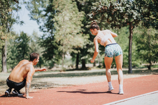 Dois desportistas em sportswear praticam rodas sincronizadas no parque, inspirando-se mutuamente em um treino ao ar livre ensolarado. - Foto, Imagem