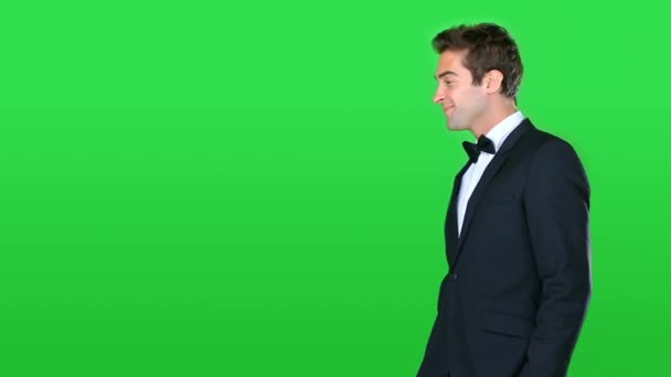 Man in tuxedo, face and arms crossed, green screen with fashion and black tie style for party or event on studio background. Confidence, model smile with suit and bowtie, mockup space and portrait. - Footage, Video