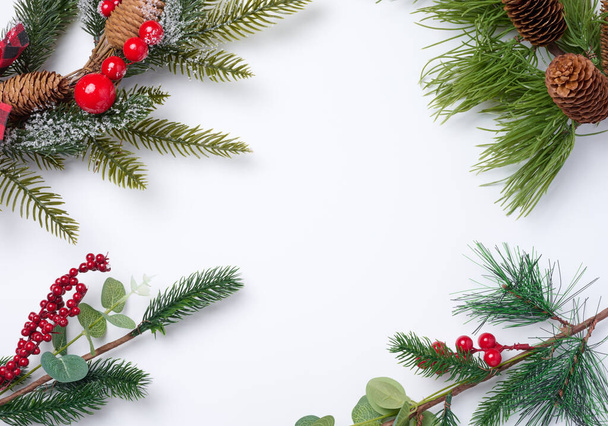 Karácsonyi fenyő ágak dekorációval fehér háttérrel, felülnézet - Fotó, kép