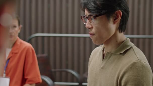 Přes rameno záběr frustrovaný asijský muž sdílet své pocity a emoce během skupinové terapie - Záběry, video