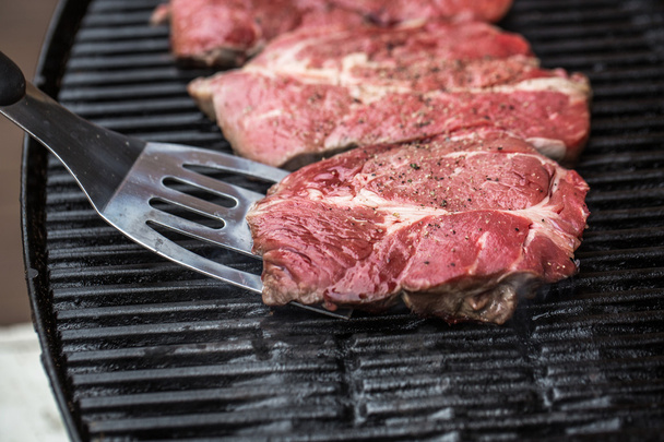 Beef steaks on grill or BBQ with spatula - Photo, Image