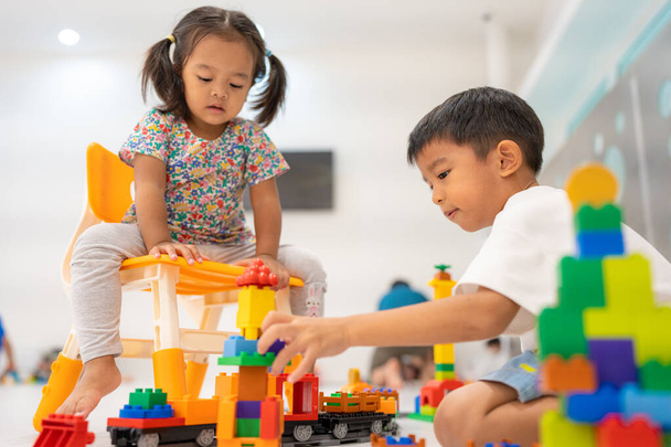 Küçük sevimli çocuk ve kız plastik blok oyuncağı oynuyorlar hayal gücü eğitimi kavramını geliştiriyorlar. - Fotoğraf, Görsel