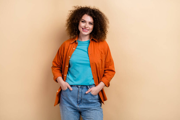 Photo portrait of pretty young girl hands pockets jeans posing dressed stylish orange outfit isolated on beige color background. - Valokuva, kuva
