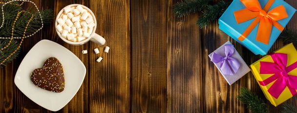 Cioccolata calda con marshmallow, pan di zenzero e regalo di Natale sullo sfondo di legno. Vista dall'alto. Copia spazio. - Foto, immagini