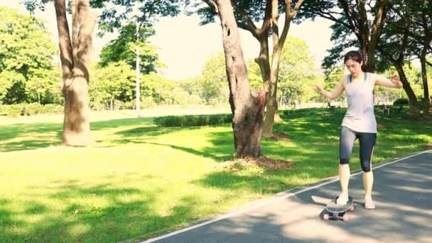 Fiatal ázsiai nő játszik X Játékok gyakorló gördeszka a játszótéren a parkban, gyakorló lassú játék a biztonság kedvéért. - Felvétel, videó