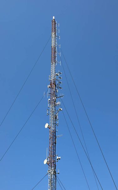 высокий ретранслятор телефонных и информационных сигналов с очень мощными антеннами - Фото, изображение