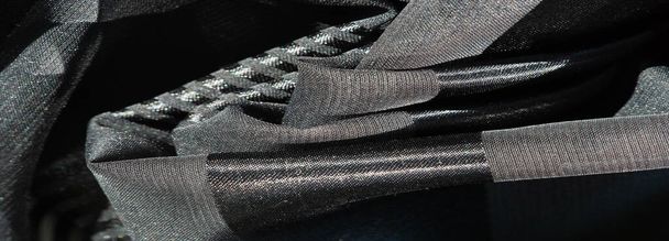 Seidenstoff. helles transparentes Seidengewebe mit Streifen in verschiedenen Größen, schwarz. Textur, Hintergrund, Muster, - Foto, Bild