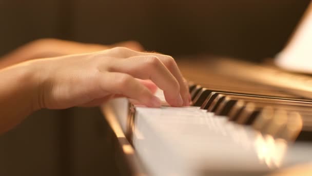 Primer plano de la mano de un pequeño estudiante tocando el piano. Feliz joven asiática aprendiendo y practicando el piano. Enfoque selectivo. - Metraje, vídeo