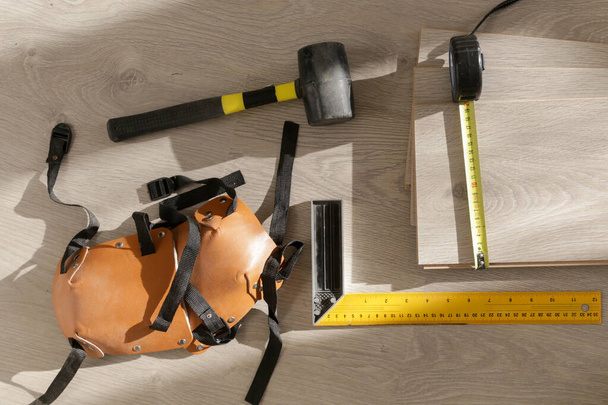 Rubber hammer, ruler with angle bar, tape meter, jig saw and other tools for installation of laminate vinyl floor. Home improvement, new floor installation. - Photo, Image