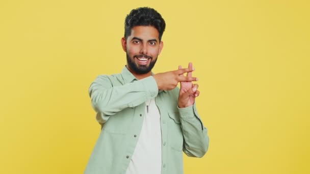 Хашиг. Індійський чоловік, який показує хрест-символ з пальцями, любить мічені повідомлення, популярний вірусний соціальний медіа-контент, знак, щоб слідувати інтернет-інтернет тенденціям. Арабський молодий хлопець на жовтому фоні студії - Кадри, відео