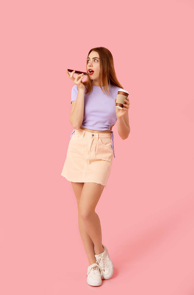 Όμορφη γυναίκα με κινητό τηλέφωνο και φλιτζάνι καφέ αποστολή φωνητικού μηνύματος σε ροζ φόντο - Φωτογραφία, εικόνα