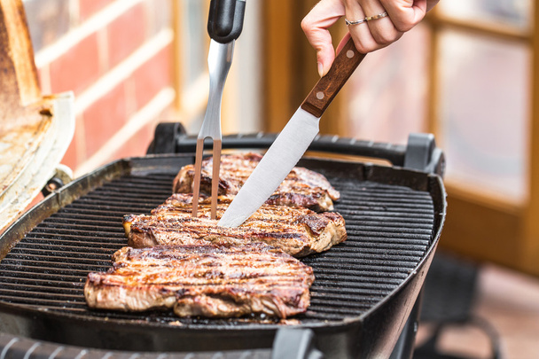 Steaks de boeuf sur gril avec fourchette barbecue et couteau
 - Photo, image