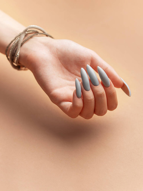 Primo piano della mano della donna con smalto grigio  - Foto, immagini