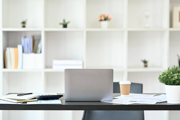 Kényelmes munkahely laptoppal, dokumentumokkal és irodai eszközökkel fekete fa asztalon. - Fotó, kép