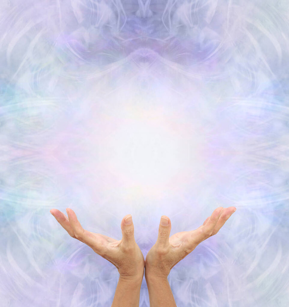 Plantilla de Mensaje de Terapeuta Sanadora de Energía - manos de palma abierta femenina mirando hacia arriba contra fondo simétrico etéreo angelical con espacio de copia arriba para mensaje espiritual - Foto, imagen